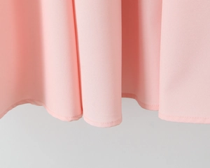 Detail van de roze jurkzoom met fijne stiksels en soepel vallende chiffon stoffen