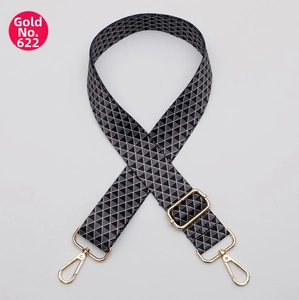 Detail of adjustable wide shoulder strap with black and white geometric pattern and gold clips