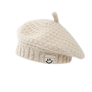 Berretto in maglia beige per bambini con trama a grana grossa e toppa con sorriso