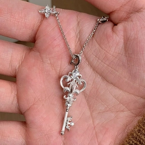 Detailed view of an intricate stainless steel key pendant necklace with zircon star charm