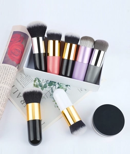 Detail of round flat-top foundation brushes with colorful handles and soft bristles