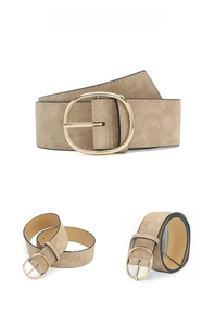 Détails d'une ceinture en daim kaki avec une grande boucle ovale dorée et coutures fines