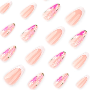 Long almond press-on nails with French tips and floral bow patterns in nude pink