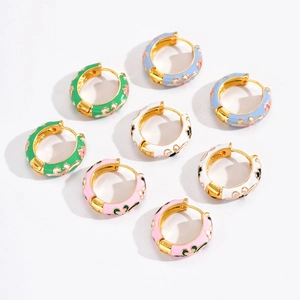 Macro shot of colorful enamel floral hoop earrings with vintage gold-plated filigree details