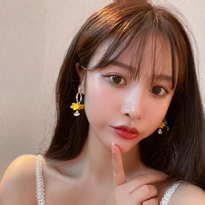 Elegant yellow flower drop earrings with clear crystal charms shown worn on ear