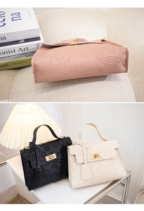Detailansicht von Lederhandtaschen mit Cartoon-Prägung, Metallverschluss und Anhängern