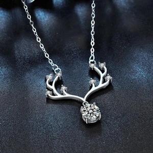 Macro shot of silver deer horn pendant featuring sparkling moissanite and fine silver chain