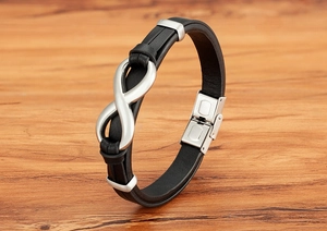 Detailed macro view of men's leather bracelet with stainless steel infinity clasp