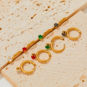 Vintage stainless steel hoop earrings with colorful zircon stones on textured stone
