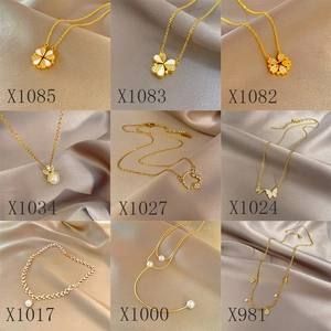 Vue détaillée de neuf colliers de luxe en titane doré avec trèfles et pendentifs perles