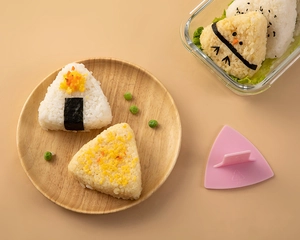 Close-up of pink triangular rice ball mold with handle and finished onigiri for bento