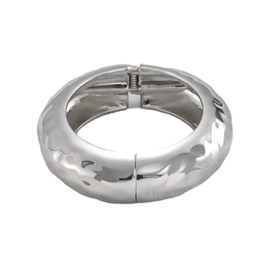 Detail of silver textured wide cuff bangle with hammered surface and hinge closure