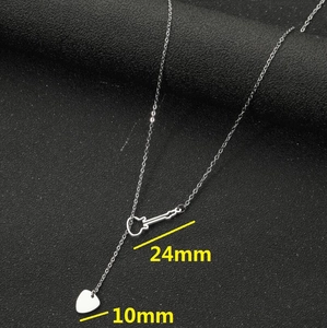 Collier moderne en acier inoxydable avec pendentifs guitare et médiator sur fond noir