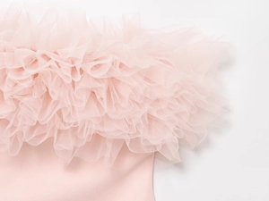 Detailansicht von geschichtetem rosa Falten-Tüllstoff und Rüschen an einem Damenkleid