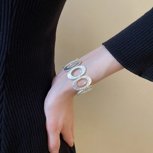Close-up of a silver-toned hammered metal bracelet with oval link chain design