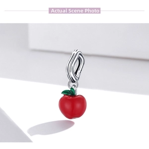 Macro detail of S925 sterling silver red apple charm with enamel finish and leaf detail