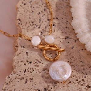 Close-up of 18K gold plated necklace featuring baroque pearls and classic OT toggle clasp
