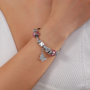Detail of adjustable crown beaded bracelet with pink crystals and heart charms on wrist