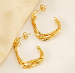 Détail des boucles d'oreilles créoles torsadées plaquées or 18 carats au design moderne