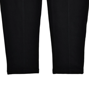 Gros plan sur les jambes d'un body noir montrant la texture du tissu et les coutures de l'ourlet