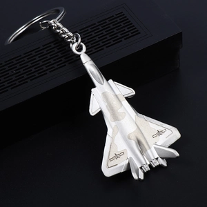 Silver fighter jet keychain in a sleek metal finish displayed on a black gift box