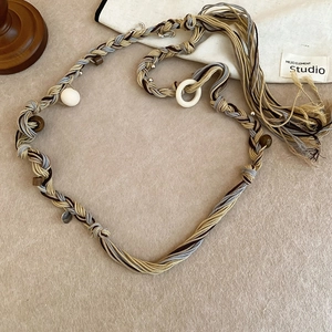 Detail of bohemian hand-woven waist chain with wooden beads and fringed tassels