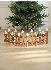 Close-up of wooden Christmas fence with artificial snow berries and pine needles