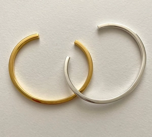 Detail of minimalist 3mm S925 sterling silver open bangles in gold and silver finish