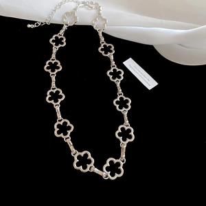 Detail of silver floral choker featuring hollow petal links and adjustable lobster clasp