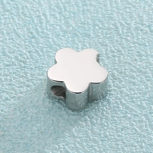 Detail shot of silver flower-shaped metal bead with a side hole for jewelry making
