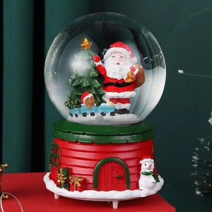 Detail of Christmas crystal ball music box with Santa and red house base design