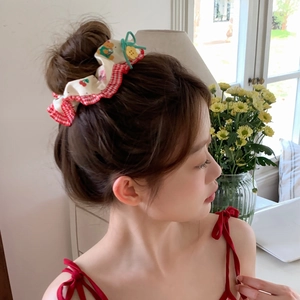 Detail of floral scrunchie with cherry bear print, red checkered trim and yellow button