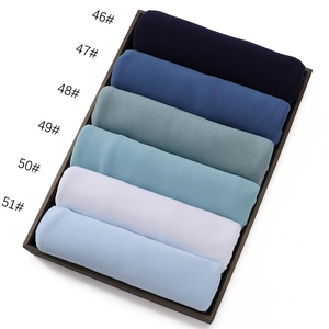 Close-up of jersey cotton fabric rolls in six colors including blue, green, and white