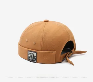 Detail of vintage brown canvas brimless docker cap with retro denim patch and metal buckle