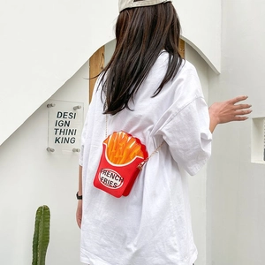 Creative red french fries crossbody bag with golden chain strap worn by a model