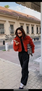 Street style shot of a red faux fur mid-length coat with horizontal stripe design