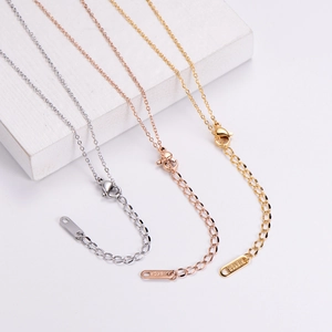 Macro detail of gold, rose gold and silver chains with 18KGP engraving and lobster clasp