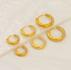 Detailed view of three pairs of 18K gold-plated stainless steel hoop earrings with crystals