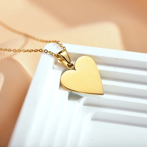 Macro view of polished gold plated heart pendant necklace on minimalist display