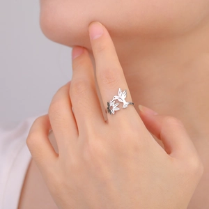 Silver hummingbird and flower ring in 18K plated stainless steel on a model's hand