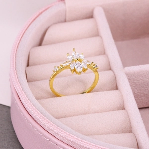 Detailed close-up of a luxury gold floral ring with marquise-cut zircon in a pink box