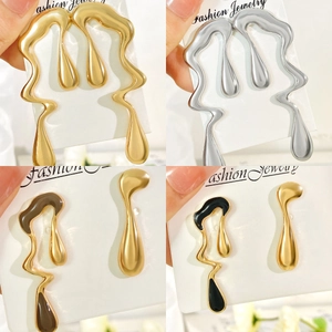 Detail of fluid metal drop earrings in gold, silver, and bicolour finishes