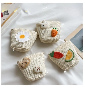 Dettaglio di mini borse in paglia intrecciata per bambini con motivi colorati di cartoni