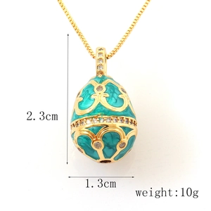 Macro detail of enamel egg pendant with blue finish, gold patterns and 2.3cm height spec