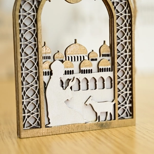 Detail of layered wood laser-cut Ramadan ornament with Islamic dome and silhouette