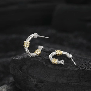 S925 silver C-shaped hoop earrings with gold accents and zircon on dark stone backdrop