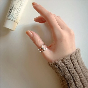 Close-up of minimalist 925 sterling silver ring with a stylish double-loop knotted design