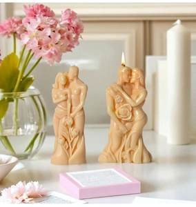Detailed macro view of white lovers candle with intricate rose relief textures and warm glow