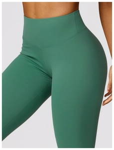 Detail shot of emerald green high-waisted yoga leggings showing seamless hip fit