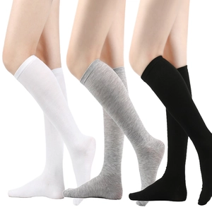 Detailed knit texture of white grey and black knee-high striped socks for women